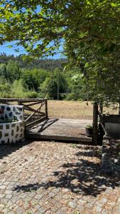 a park with a wooden fence and a tree at LouzaNook - Casa do Moinho in Lousã