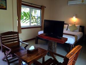a bedroom with a bed and a tv on a table at Aranyaprathet Riverside resort in Ban Khok (1)