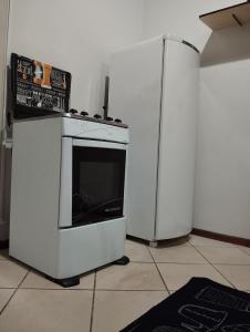 a kitchen with a white stove and a refrigerator at Apartamento Centro Cruz Alta in Cruz Alta
