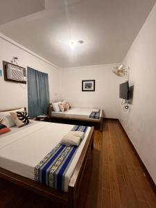 a bedroom with two beds and a television in it at Casa Montemar Heights in Coron +49 photos