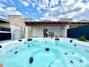 patio con vasca idromassaggio di fronte a una casa di Villa with Jacuzzi - Joy Collection a Àrbatax