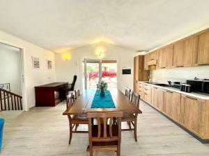 una cucina con un tavolo di legno e una sala da pranzo di Villa with Jacuzzi - Joy Collection a Àrbatax Altre 16 foto