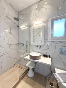 a bathroom with a sink and a glass shower at Cyclades Blue in Ornos