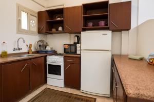 a kitchen with brown cabinets and a white refrigerator at 1038 · 2BR TownhouseBath TV Backyard in Sheikh Zayed