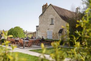 a group of people sitting at tables in front of a building at LE PRESBYTÈRE DE LA CITE ROYALE DE LOCHES in Loches