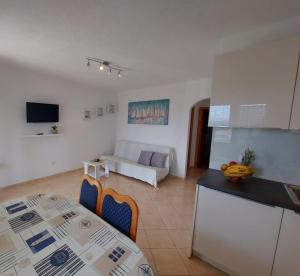 a kitchen and living room with a table and a couch at Apartments Gojevic in Bol
