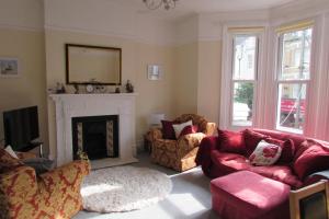 a living room with two couches and a fireplace at Idyllic Bexhill centre flat above pub in Bexhill