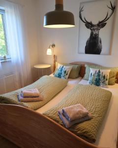 a bed with two pillows and a deer on it at Urlaubshaus-Braunlage Wohnung 1 in Braunlage