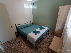 ein Schlafzimmer mit einem Bett mit blauen Kissen in der Unterkunft Με Θεα!! in Stomio