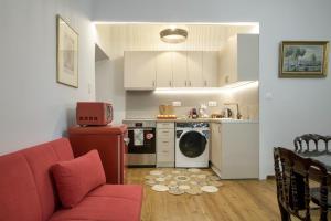 a living room with a red couch and a kitchen at Liston Suites Anastasia in Corfu