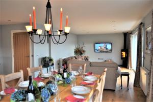 a dining room with a table and a couch at Lochalsh Lodge, Glaick, Balmacara,Kyle of Lochalsh in Balmacara