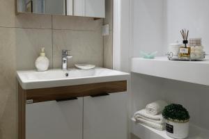 a white bathroom with a sink and a mirror at Liston Suites Anastasia in Corfu Town +66 photos