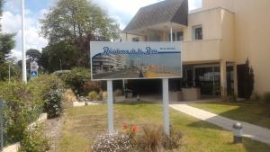 ein Schild im Gras vor einem Gebäude in der Unterkunft Résidence baie de la baule in La Baule