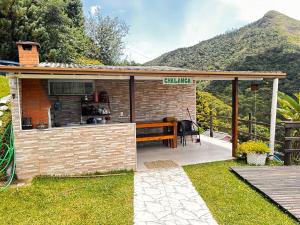 a barbecue grill with a bench on a patio at Chalanga in Nova Friburgo