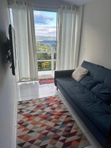 a living room with a couch and a large window at Chalanga in Nova Friburgo