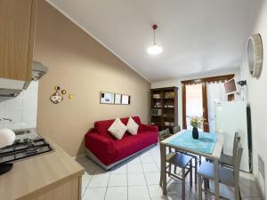 un soggiorno con un divano rosso e un tavolo di Lumier a Villasimius Altre 13 foto