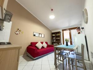 un soggiorno con un divano rosso e un tavolo di Lumier a Villasimius