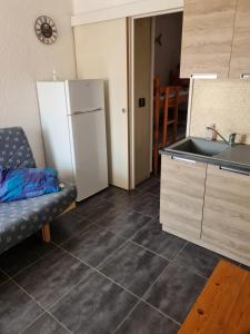 a kitchen with a refrigerator and a sink at Quatre Vent in Gruissan