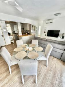 a living room with a table and chairs and a couch at Del Mar 2 Deluxe Apartment Playa del Cura Torrevieja in Torrevieja