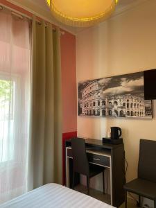 - une chambre avec un bureau, un lit et une fenêtre dans l'établissement Stefano House Vaticano Roma, à Rome