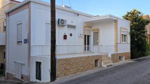 a white building with a balcony on a street at The 20A Terminal Stay N Fly in Paradeísion