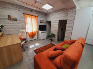 Una sala de estar con un sofá y un televisor. en Well Sized 2 Bedroom Maisonette Valletta Floriana, en Floriana