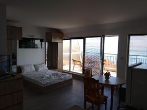 a living room with a bed and a table with a dining room at Sunny House Byala in Byala