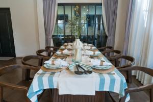 a dining room table with a blue and white striped table cloth at House 148 Patong Pool Villa 4BR Near Beach in Patong Beach +25 photos