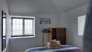 a bedroom with a bed with a towel on it at Menadue Cottage, Trenale Lane, Tintagel, Cornwall in Treknow