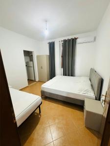 a bedroom with two beds and a couch in it at Villa Roni in Durrës
