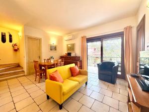 Una sala de estar con un sofá amarillo y una mesa. en Sea Whisper - Joy Collection, en Santa Maria Navarrese