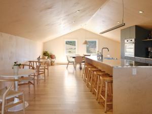 a kitchen and dining room with tables and chairs at Petit hôtel de la Montagne in Havre-Aubert