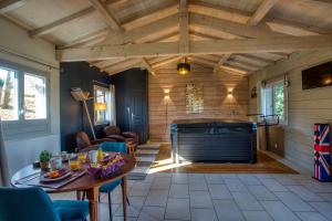 a living room with a wooden ceiling and a table at gite&spa individuel interieur privé-le bois de la pause- in Saint-Cybranet