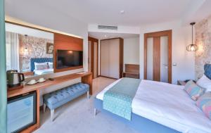 a bedroom with a large bed and a tv at Molino Hotel in Kas