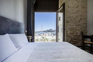 a bedroom with a large bed and a large window at Lakkios charming suites and rooms in Syracuse +62 photos