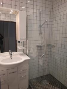 a bathroom with a sink and a shower with a glass door at Strandhgårdens BBB rum 1 in Oxie