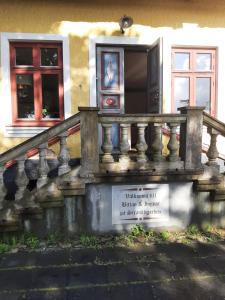 a house with a stone railing and a window at Strandhgårdens BBB rum 1 in Oxie