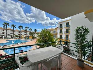 d'un balcon avec une table et des chaises, ainsi que d'une piscine. dans l'établissement Grupo Morgado - Quinta do Morgado - Morgado Luxury, à Tavira