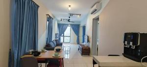 a living room with blue curtains and a table and a couch at Sunway Geo Suites AG0E at Sunway City by Ezprop in Subang Jaya