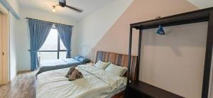 a bedroom with a bed with a teddy bear on it at Sunway Geo Suites AG0E at Sunway City by Ezprop in Subang Jaya