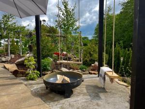 a large stone tub sitting in a garden at Garden Residence - The Lotus in Drahobudice