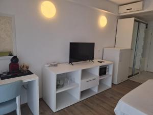 a living room with a tv on a white cabinet at My Blaxy apartment in Olimp