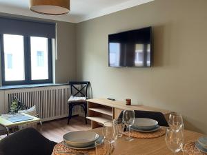 a dining room with a table with plates and wine glasses at Louise Boutique Apartment 2 in Friedrichshafen