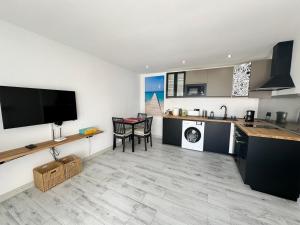 a kitchen with a table and a tv on a wall at Michas House in Puerto del Carmen