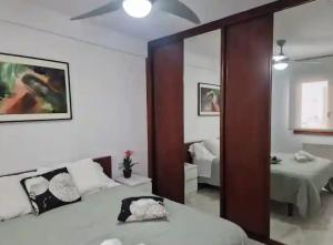 una camera con letto e specchio e una camera da letto di Apartamento Gascona a Oviedo