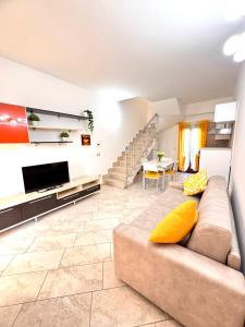 a living room with a couch and a television at Suites Dreams Fiumicino Sole in Fiumicino