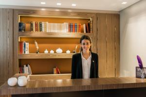 a woman standing in front of a library at Hôtel Le Tourville by Inwood Hotels in Paris
