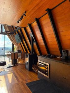 a kitchen with a stove and a dining room with a table at Cabanas Duas Faces - Urubici in Urubici