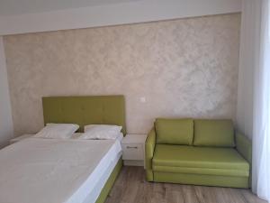 a bedroom with a bed and a green chair at My Blaxy apartment in Olimp +13 photos