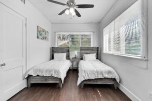two beds in a room with a ceiling fan at Splendid Mediterranean Retreat Gorgeous Outdoor in North Miami